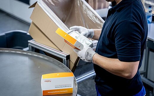 Mitarbeiter prüft vorkonfektionierte pharmazeutische Faltschachtel im PrePackaging Service von Faller Packaging