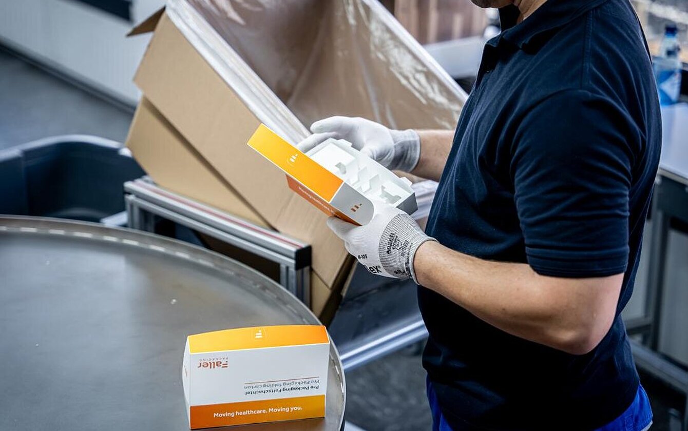 Quality control at Faller Packaging’s PrePackaging Service – an employee inspects pre-assembled folding boxes.