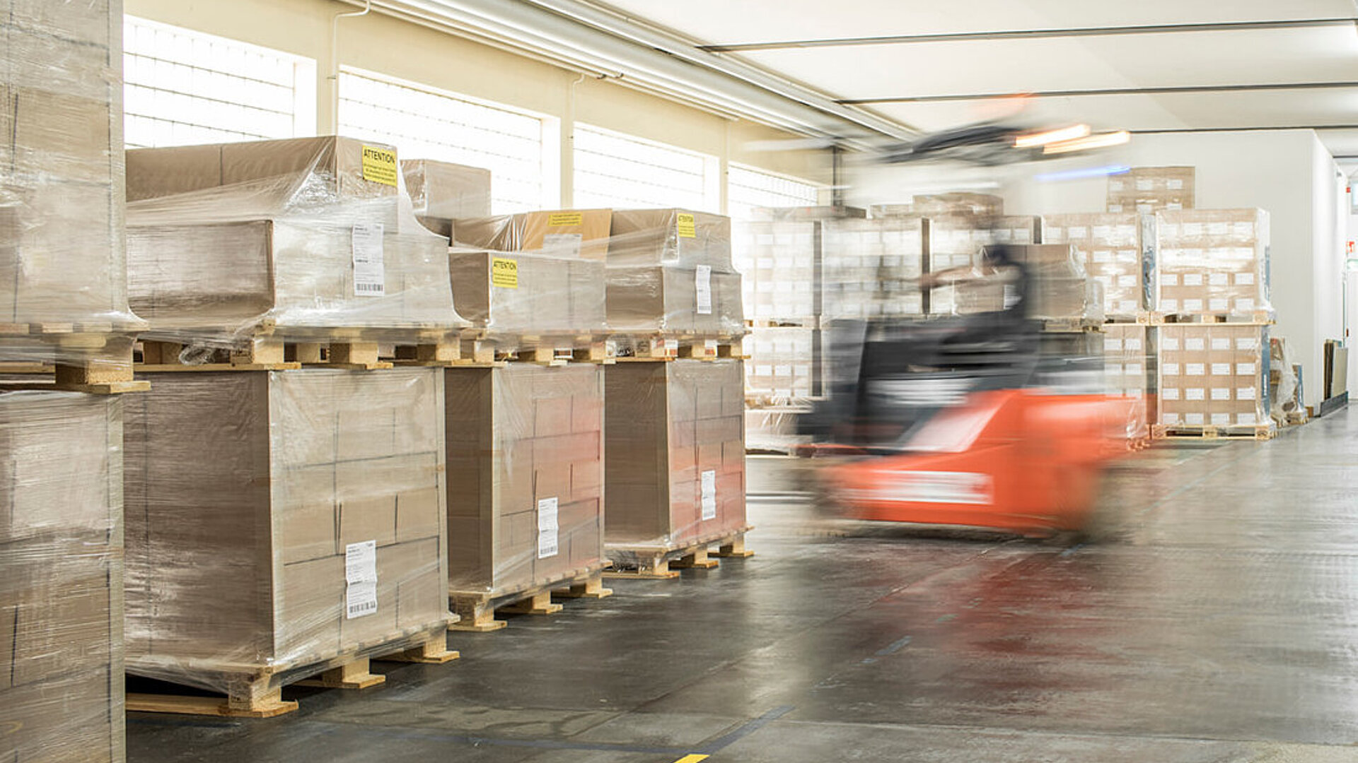 Efficient supply chain at Faller Packaging: pallet warehouse with forklift for smooth pharmaceutical logistics.