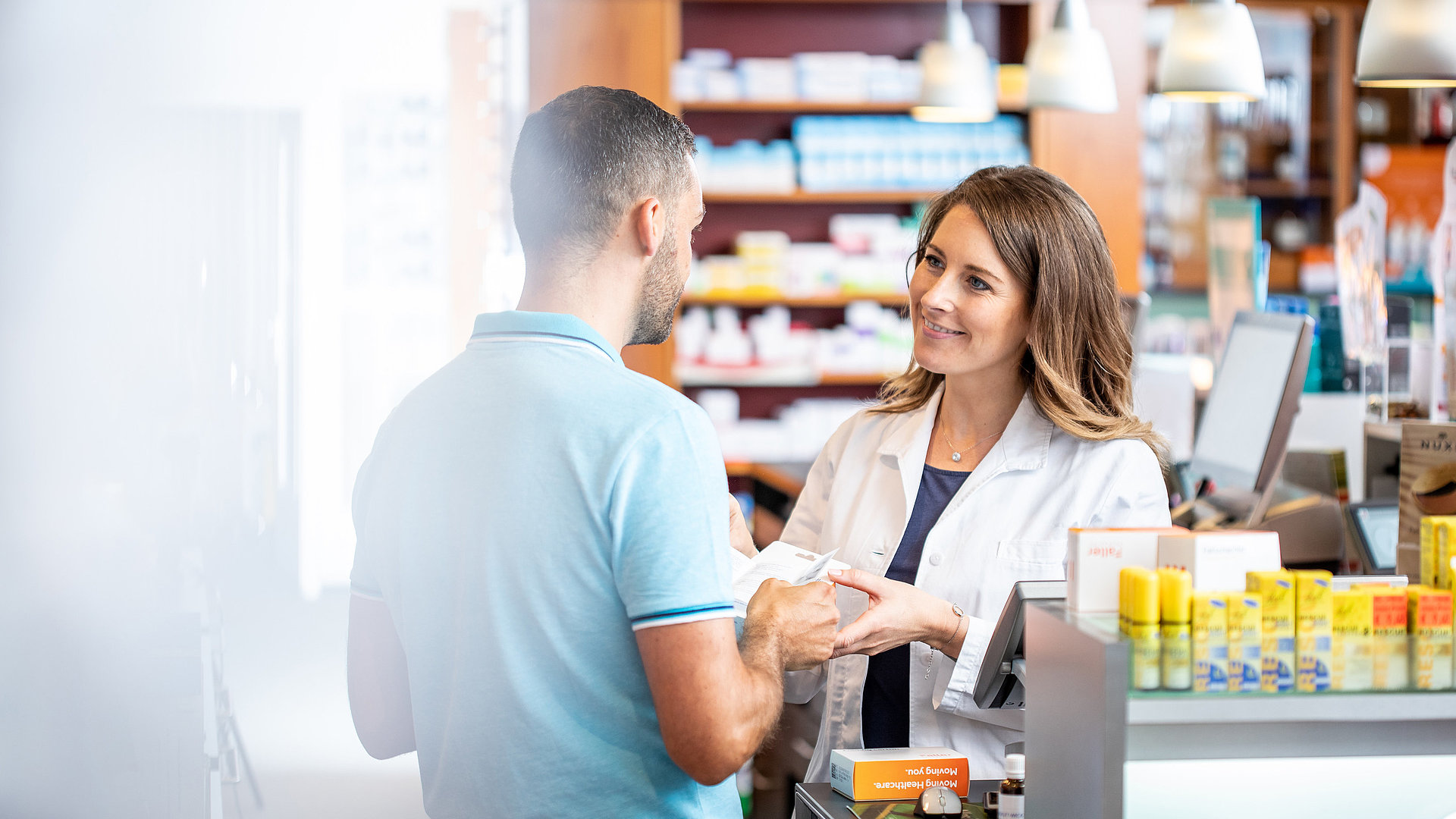 Apothekerin berät Kunden zu Medikamentenverpackungen – Faller Packaging Lösungen für mehr Compliance und Convenience im Alltag.